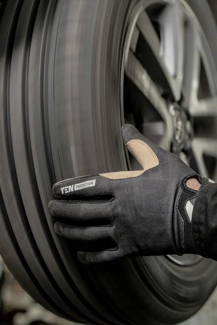 a close up of a person wearing a glove on a tire